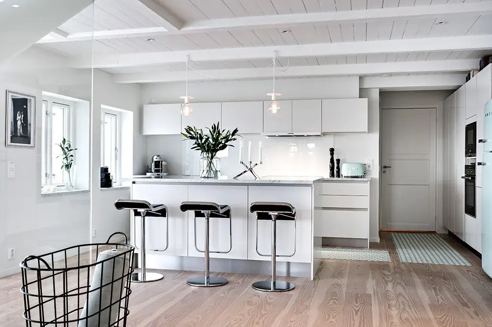 Renovering av kök i vitt och marmor med integrerade vitvaror.