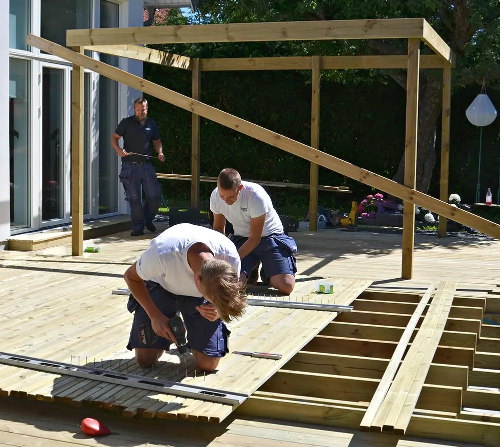 Snickare och hantverkare som bygger trädäck och pergola.